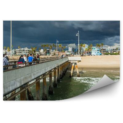 Fototapeta Mólo Pláž Oceán Mrakodrapy Palmy Ľudia Tmavé Mraky