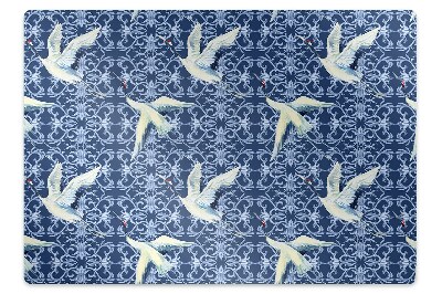 Podložka pod stoličku Žeriavy na modrom ornamentálnom pozadí,