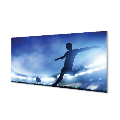 Obraz na skle Futbalista kope do lopty modré pozadie