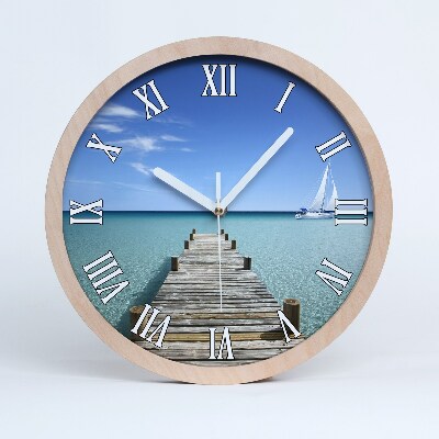 Nástenné drevené hodiny Mólo s plachetnicou na mori.