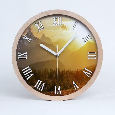 Nástenné drevené hodiny Horská krajina pri západe slnka.